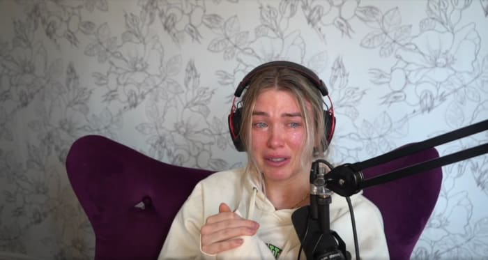 A crying woman in front of a microphone.